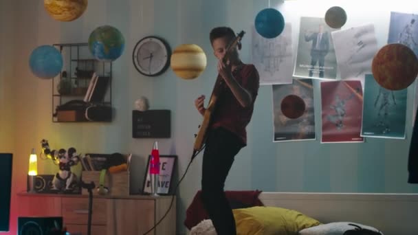 Adolescente rocker esibendosi sul letto in serata — Video Stock