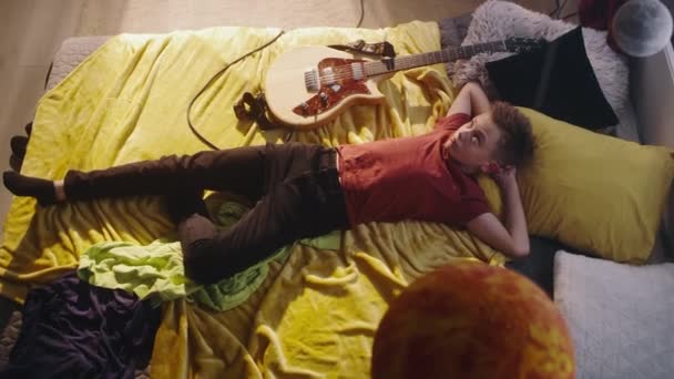 少年吉他手躺在床上休息 — 图库视频影像