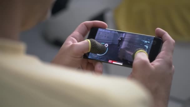 Cultivo chico jugando shooter en el teléfono celular — Vídeo de stock