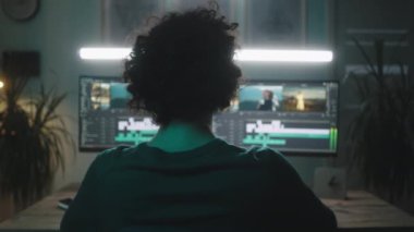 Akşamları görüntüyü düzenlemek için bilgisayarı kullanan adam