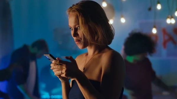 Žena flirtování přes textové zprávy během párty — Stock fotografie