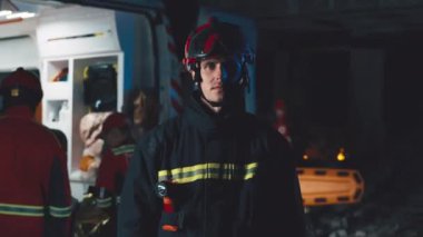 Geceleri ambulans arabasının yanında duran bir erkek kurtarma görevlisi.