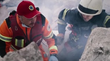 Sağlık görevlisi ve kurtarma görevlisi molozları tartışıyor