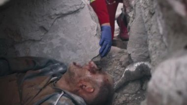 Erkek kazazede kadın sağlık görevlisiyle konuşuyor.