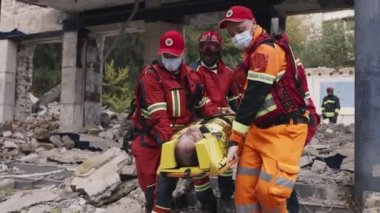 Hayatta kalanları minibüse taşıyan çeşitli sağlık görevlileri