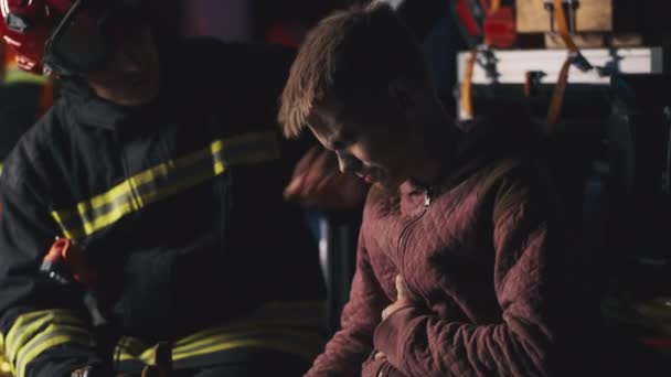 Rescatadores apoyando a sobreviviente adolescente por la noche — Vídeos de Stock