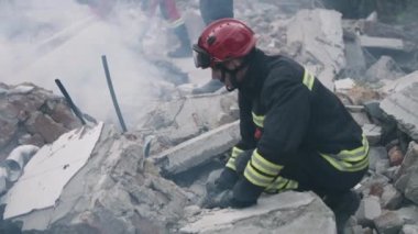 Erkek kurtarma ekipleri beton molozları kaldırıyor