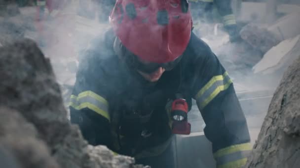 Male rescuer talking to survivors under rubble — Stock Video