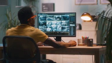 Siyah adam güvenlik videolarını izliyor.