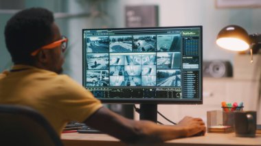 Siyah adam güvenlik videolarını izliyor.