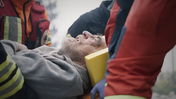 Paramedics carrying injured man after disaster