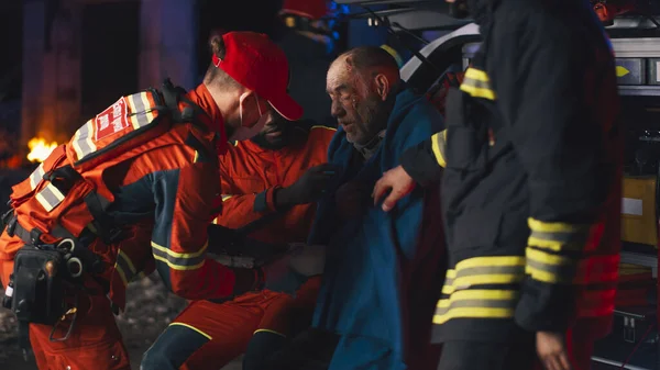 Diverse paramedics taking care of elderly patient