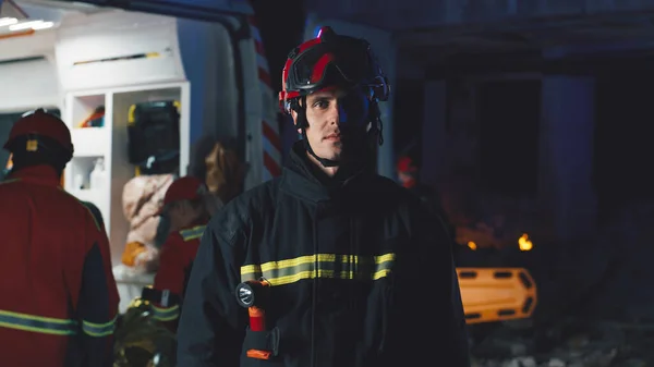 Male rescuer standing near ambulance car at night — Stock Photo, Image