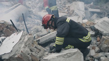 Erkek kurtarma ekipleri beton molozları kaldırıyor