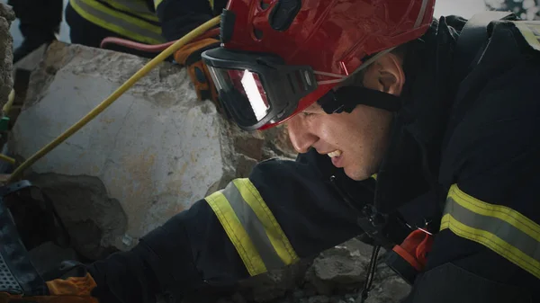 Male rescuer examining rubble and talking — Stock Photo, Image