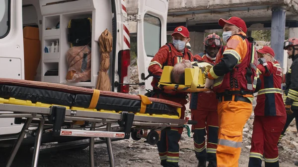 Divers ambulanciers paramédicaux préparent le survivant pour le transport — Photo