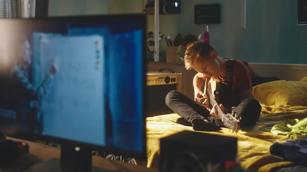 Nastolatek gitarzysta próby podczas lekcji online — Zdjęcie stockowe