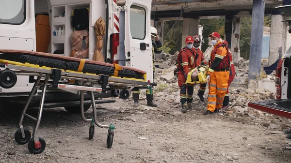 Divers ambulanciers paramédicaux préparent le survivant pour le transport — Photo