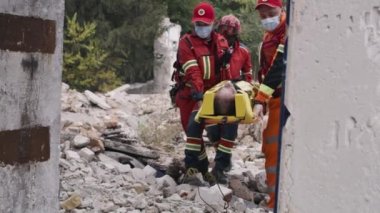 Sağlık görevlileri felaketten sonra hayatta kalanları taşıyorlar.