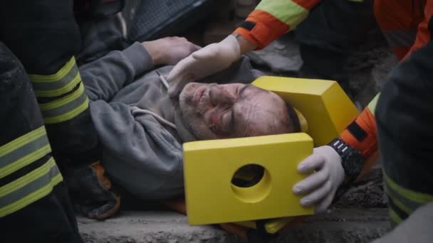 Rescuers fixating head of injured man — Stock Video