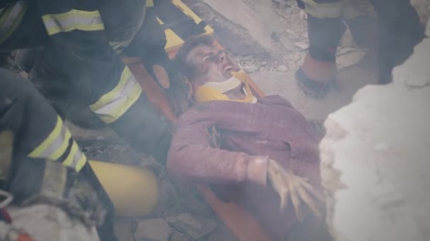 Travailleurs des services d'urgence tirant un survivant des décombres — Video