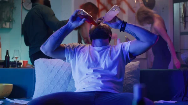 Mężczyzna pijący alkohol podczas imprezy na kanapie — Zdjęcie stockowe