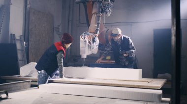 Zanaatkar meslektaşıyla polimer bloğu tartışıyor