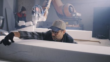 Olgun adam atölyede bloğu kontrol ediyor