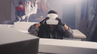 VR kulaklıklı adam polimer bloğu inceliyor