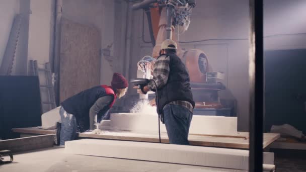 Sanatçılar değirmen makinesinin altındaki plastik bloğu inceliyor — Stok video