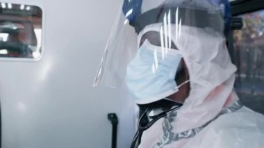 Salgın sırasında ambulansta tablet kullanan siyah sağlık görevlisi