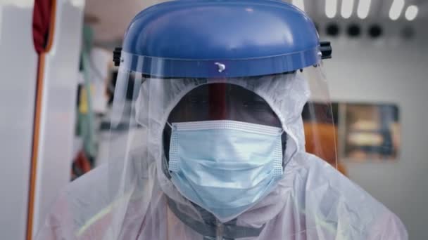 Ambulancier afro-américain en costume hazmat regardant la caméra — Video