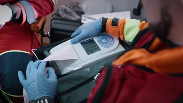 Oříznout zdravotníky provádějící EKG test v sanitce — Stock video