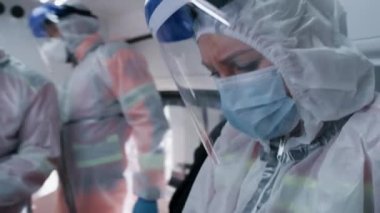 Kadın doktor ve meslektaşları ambulansla hastalarıyla ilgileniyorlar.
