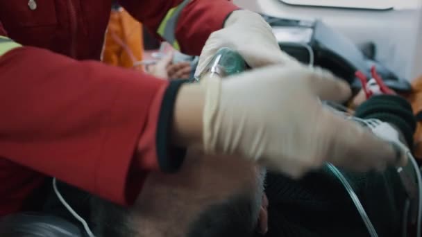 Crop doctor putting oxygen mask on unconscious man — Vídeo de Stock
