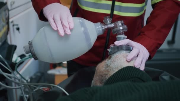 Oříznout zdravotníka pomocí kyslíkové pumpy na člověka — Stock video