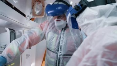 Sağlık görevlileri ambulansta yaşam destek makinesi kullanıyor.