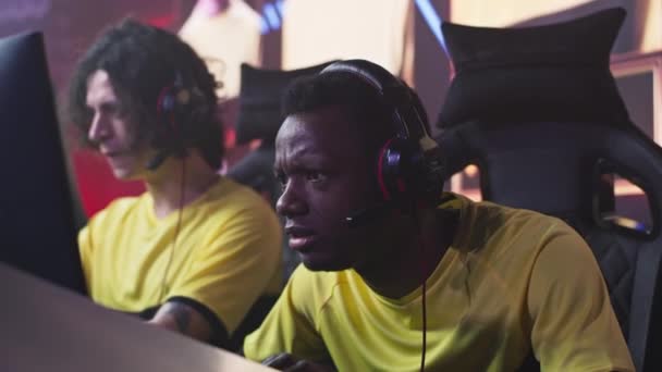 Афроамериканский геймер разговаривает с товарищами по команде во время матча — стоковое видео
