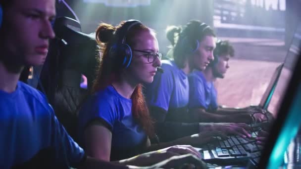 Mujer enfocada jugando videojuegos con compañeros de equipo — Vídeos de Stock
