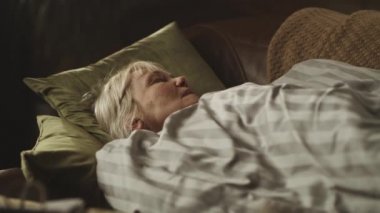 Hasta yaşlı kadın kanepede uyuyor.