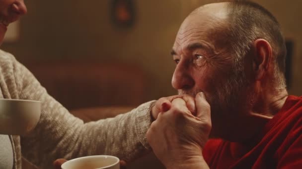 Старший чоловік цілує руку дружини — стокове відео