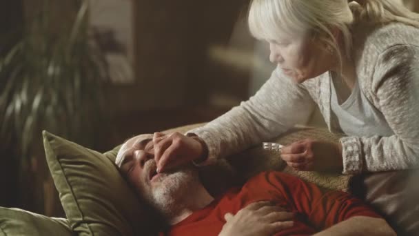 Envejecida esposa cuidando de marido enfermo — Vídeo de stock