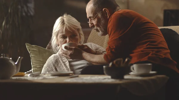 Homme âgé donnant du thé à une femme — Photo