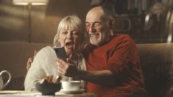 Joyeux couple âgé étreignant et faisant appel à la vidéo — Photo