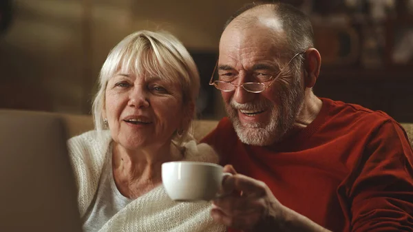 Starší pár s čajem sledující film spolu — Stock fotografie