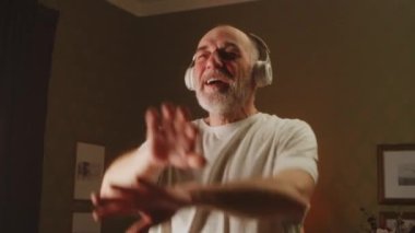 Kıdemli adam müzik dinliyor ve egzersiz yapıyor.