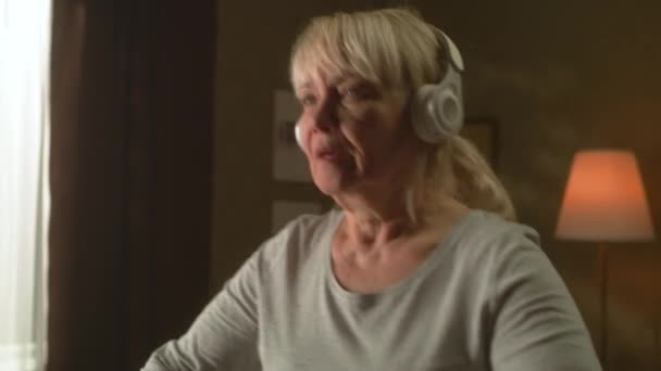 Ηλικιωμένη γυναίκα ακούγοντας μουσική κατά τη διάρκεια της άσκησης καρδιο — Αρχείο Βίντεο