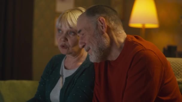 Casal idoso assistindo comédia à noite — Vídeo de Stock