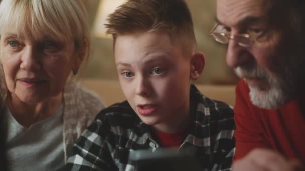 Tiener helpen grootouders om gadgets te gebruiken — Stockvideo