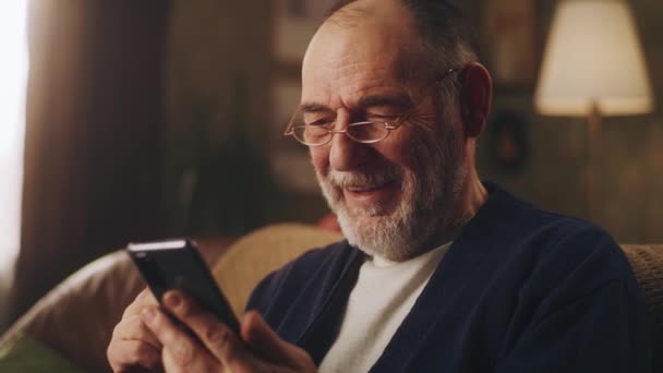 Senior man with smartphone laughing — Stock Video